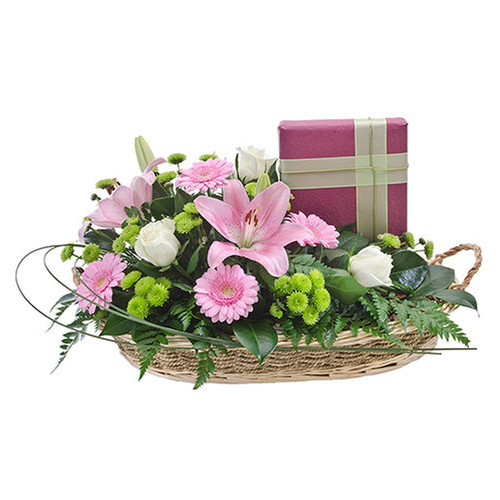 A basket brimming with flowers accompanied by a quality box of chocolates